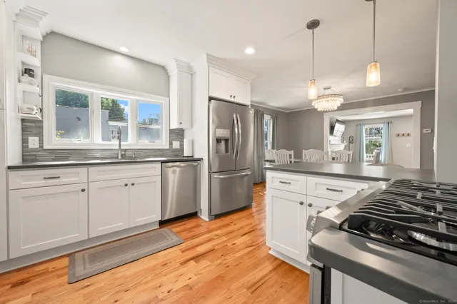 a kitchen with stainless steel appliances granite countertop a stove a sink and a refrigerator