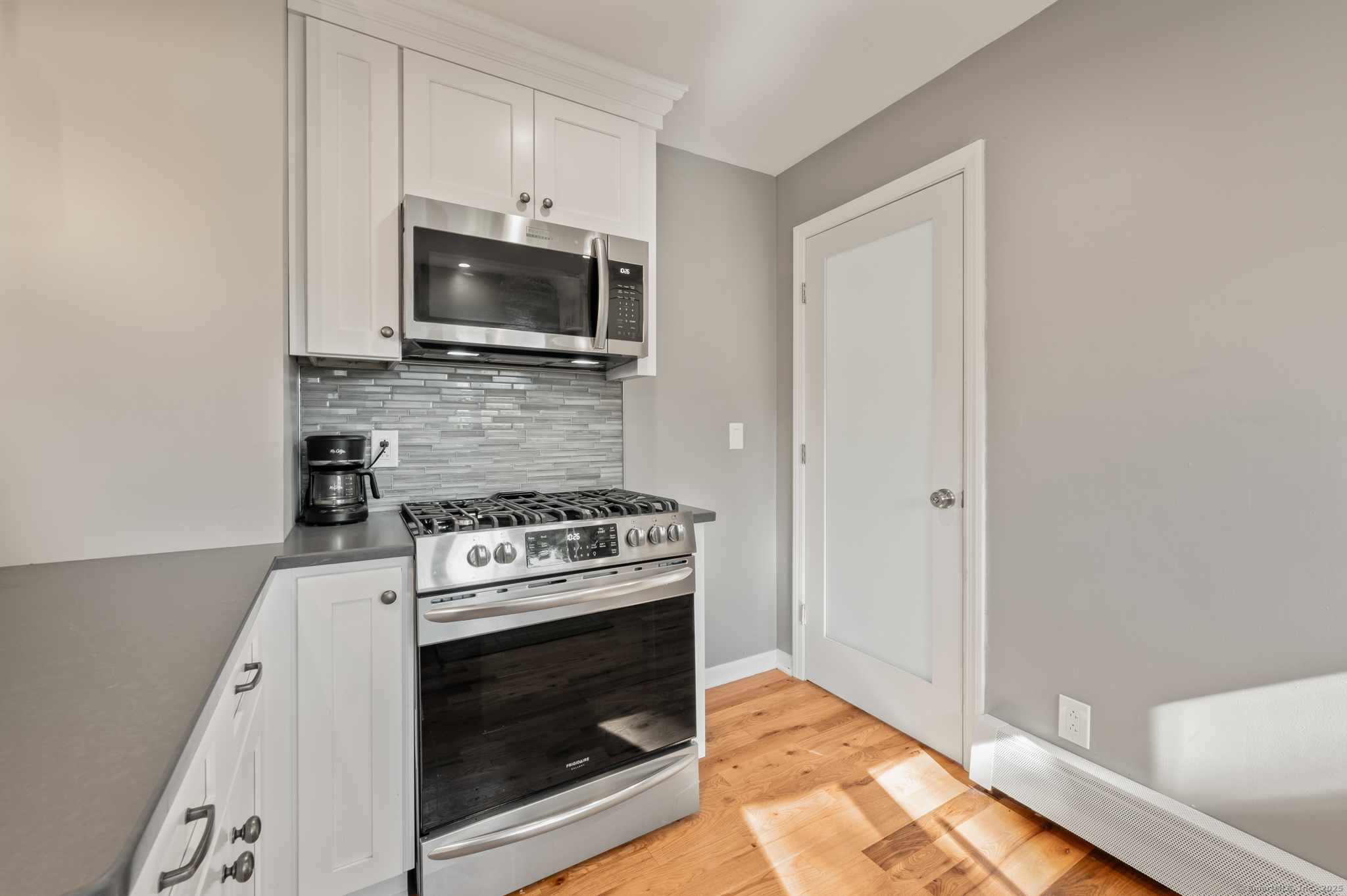 6 Howe Street Milford, CT 06460 - Photo 5 of 32 a kitchen with a stove and a microwave