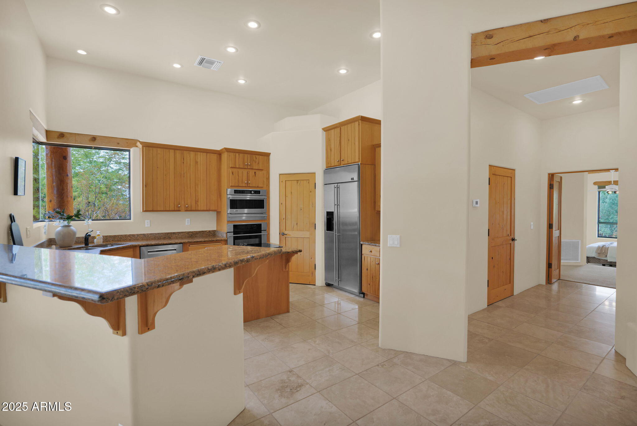 7130 East Saddleback Street, Unit 5 Mesa, AZ 85207 - Photo 17 of 57 a large kitchen with stainless steel appliances a large counter top a refrigerator and cabinets