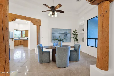a view of a dining room with furniture and a chandelier fan