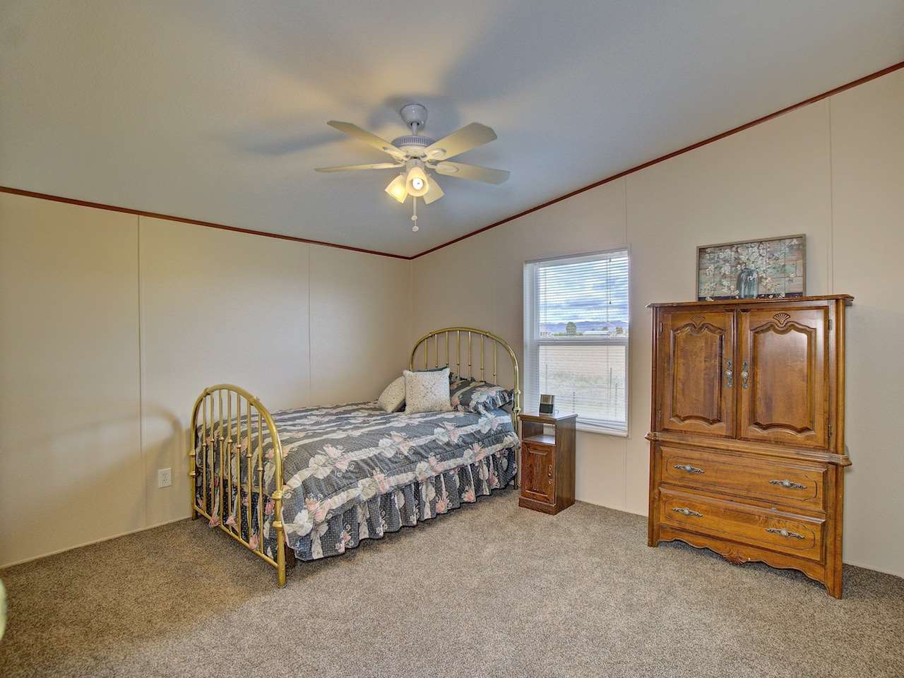 1317 Saddle Ridge Road Loma, CO 81524 - Photo 13 of 32 a spacious bedroom with a bed and a chandelier