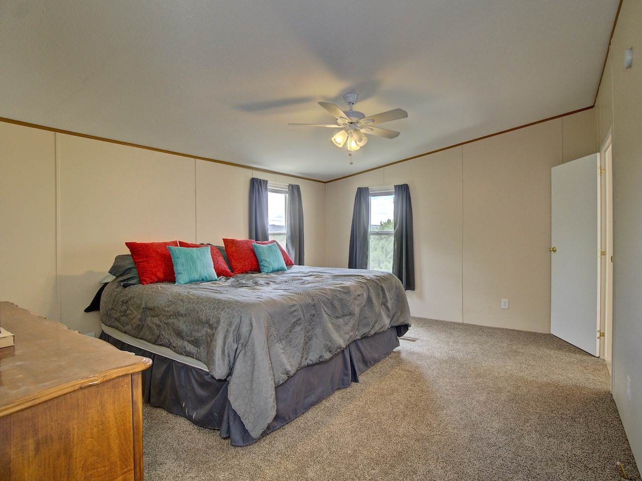 1317 Saddle Ridge Road Loma, CO 81524 - Photo 16 of 32 a bedroom with a bed and a chandelier