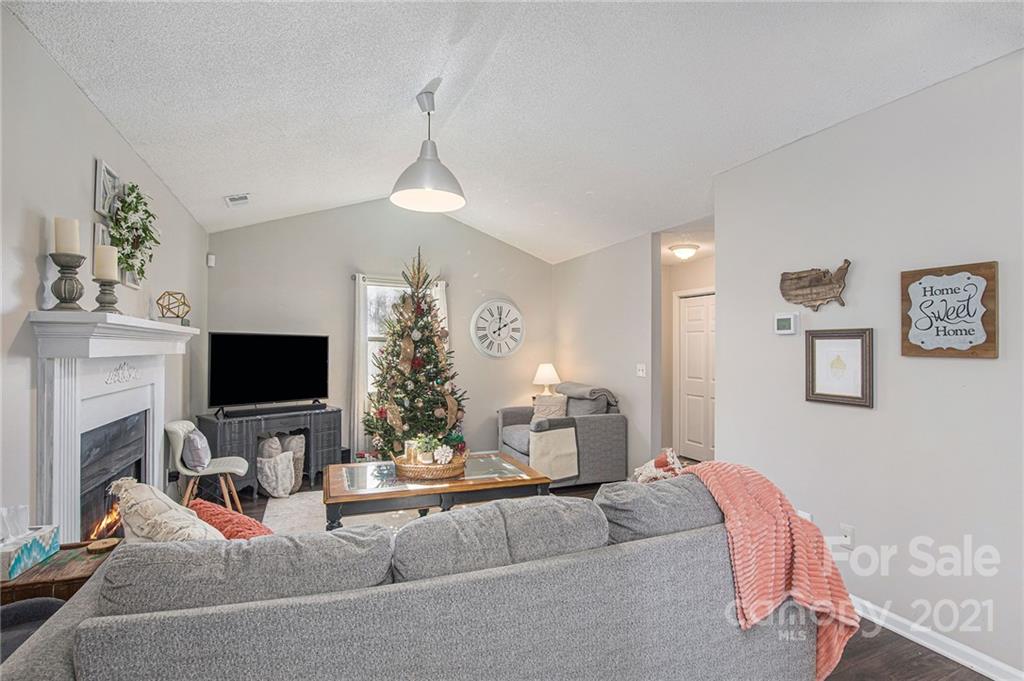 10227 Grand Junction Road Mint Hill, NC 28227 - Photo 18 of 27 a living room with furniture a fireplace and a flat screen tv