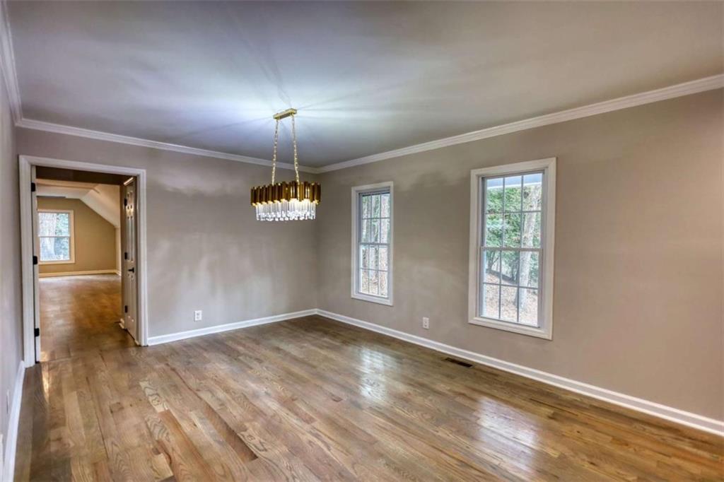 4205 Aberdeen Pass Roswell, GA 30075 - Photo 16 of 53 an empty room with wooden floor cabinet and windows