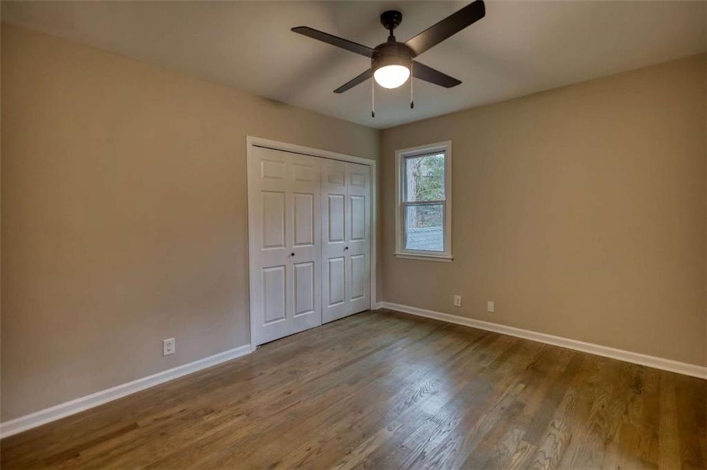 4205 Aberdeen Pass Roswell, GA 30075 - Photo 32 of 53 an empty room with wooden floor chandelier fan and windows