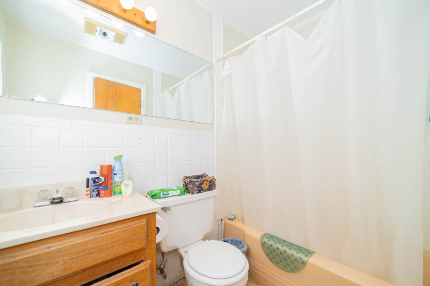 4811 43rd Street Lubbock, TX 79414 - Photo 11 of 20 a bathroom with a sink a toilet and shower curtain