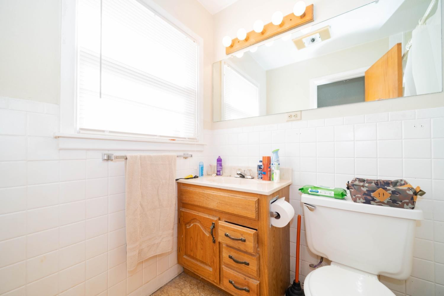 4811 43rd Street Lubbock, TX 79414 - Photo 12 of 20 a bathroom with a sink a toilet and a window