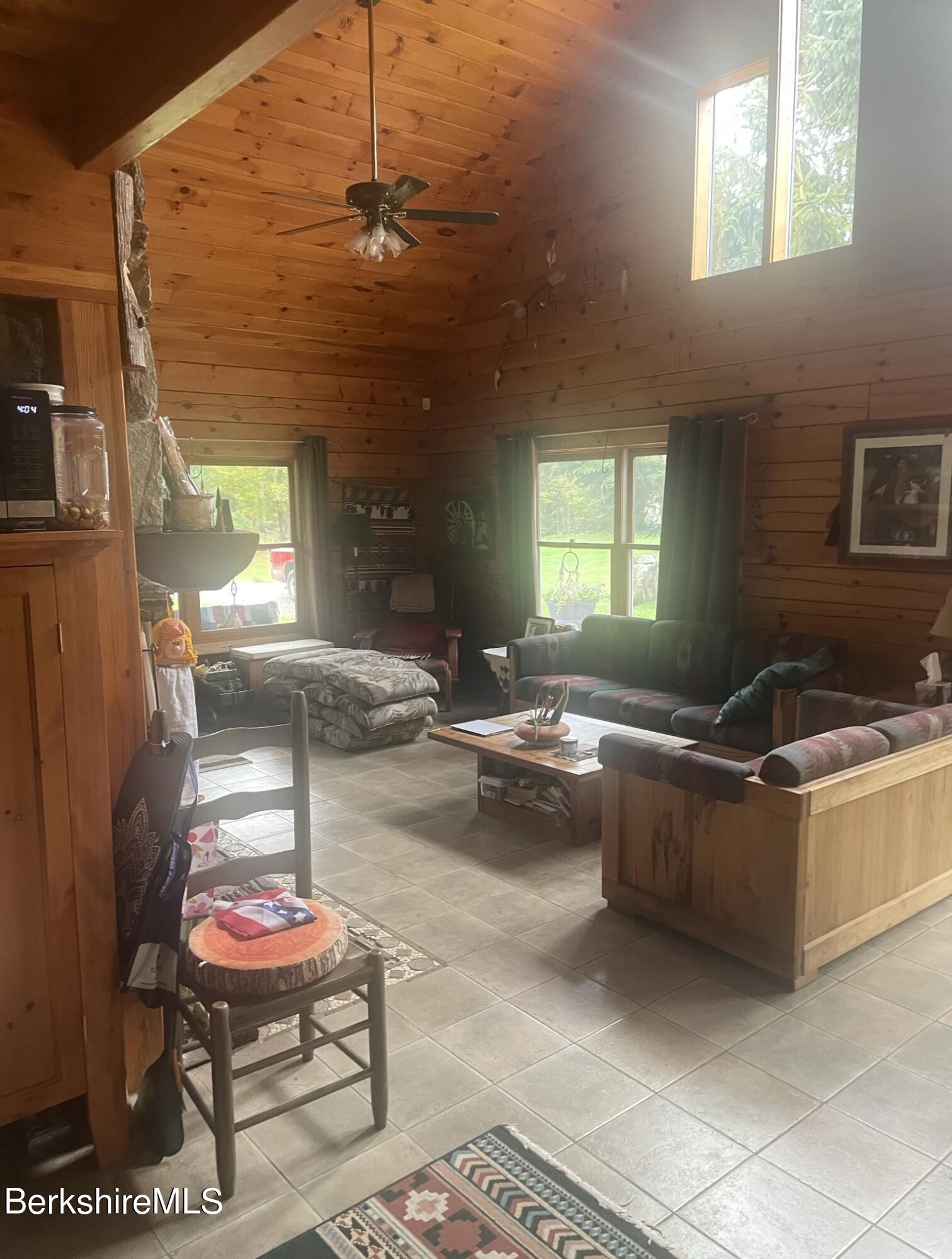 565 New State Road Savoy, MA 01256 - Photo 5 of 24 a living room with a couch and a chandelier