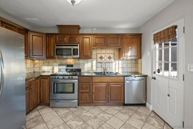 a kitchen with stainless steel appliances granite countertop a stove top oven a sink and dishwasher