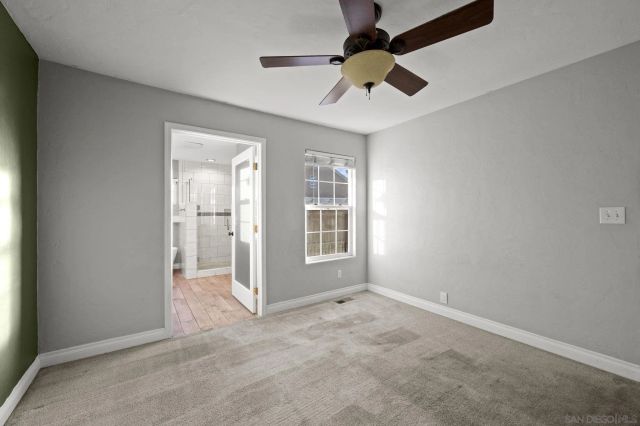 en empty room with windows and ceiling fan