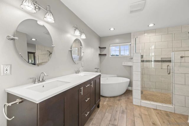 a spacious bathroom with a double vanity sink mirror and shower