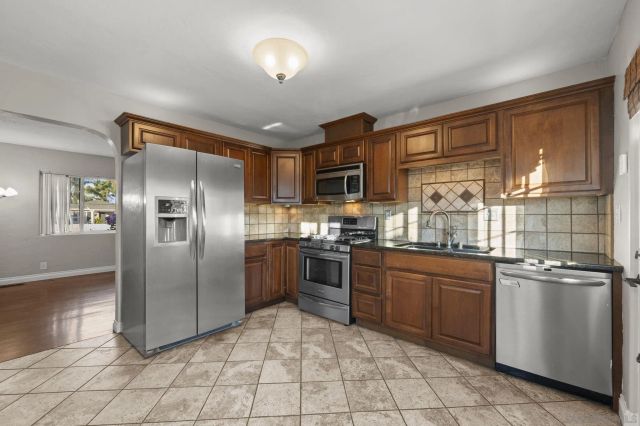 a kitchen with stainless steel appliances granite countertop a refrigerator and a stove top oven