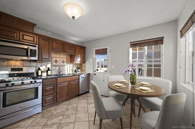 a kitchen with a dining table chairs and stove top oven