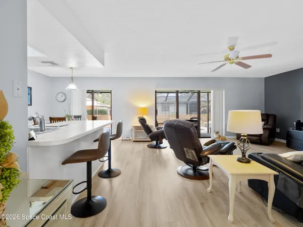 a living room with furniture a chandelier and a flat screen tv
