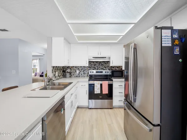 a kitchen with a sink a stove and cabinets