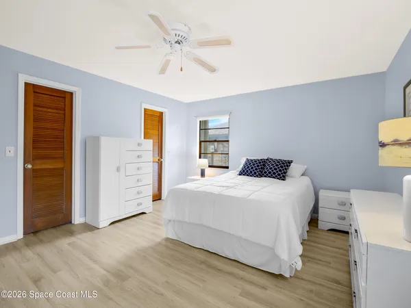 a spacious bedroom with a bed and a potted plant