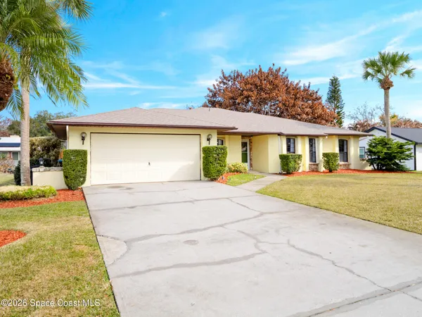 a front view of a house with a yard and palm tree