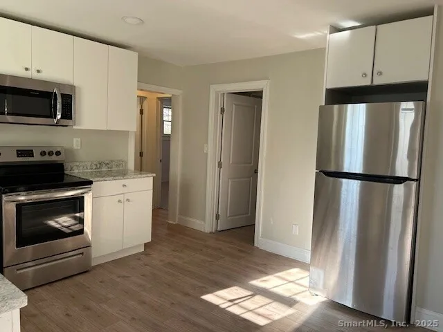 a kitchen with a refrigerator stove and white cabinets