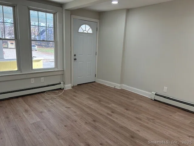an empty room with wooden floor and windows