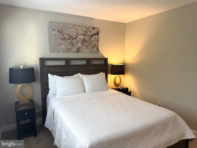 a large bed sitting in a bedroom next to a lamp