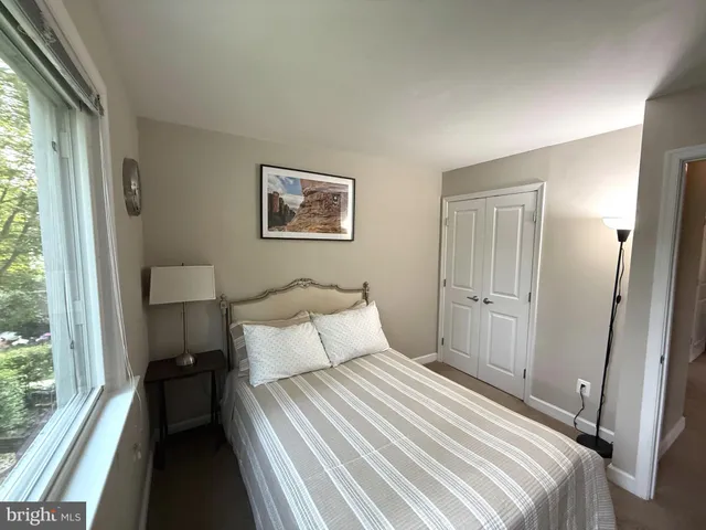 a bedroom with a bed and a large window