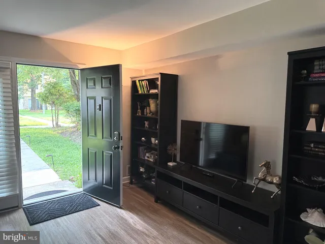 a living room with hardwood floor and a flat screen tv