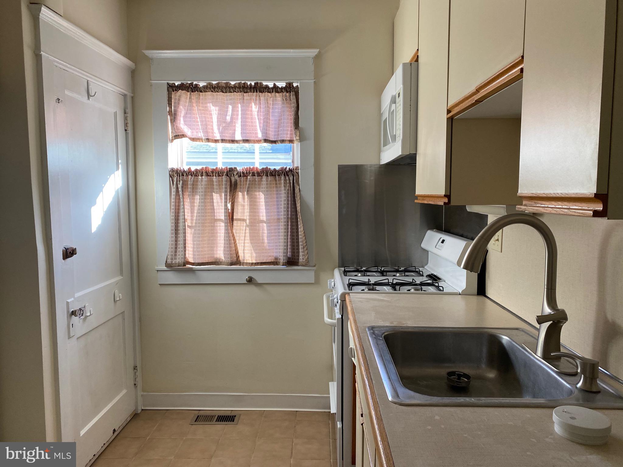 712 Grove Street Haddonfield, NJ 08033 - Photo 7 of 18 a kitchen with a sink a refrigerator and window
