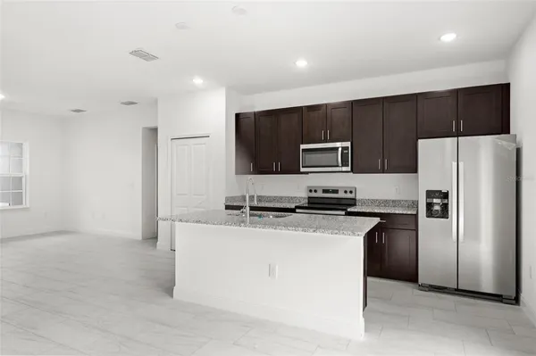 a kitchen with stainless steel appliances granite countertop a refrigerator a stove a microwave oven a sink with dishwasher and refrigerator