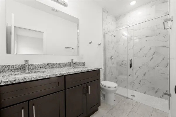 a bathroom with a granite countertop sink toilet and shower