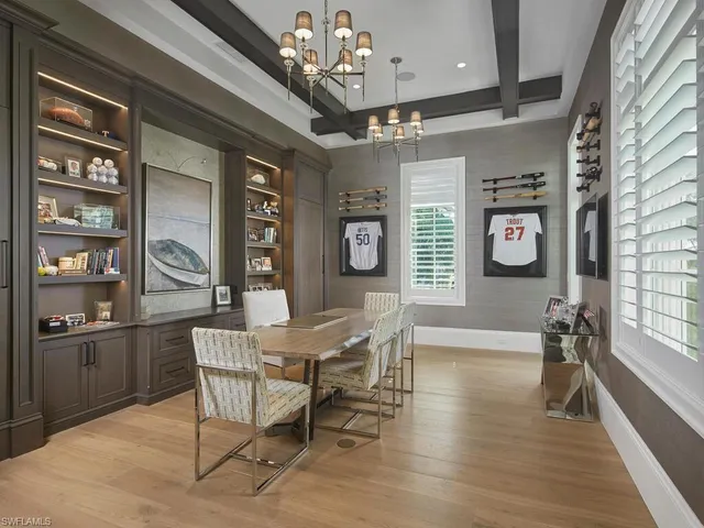 a dining room with wooden floor a chandelier a wooden table and chairs