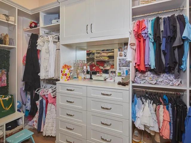 a view of walk in closet with clothes