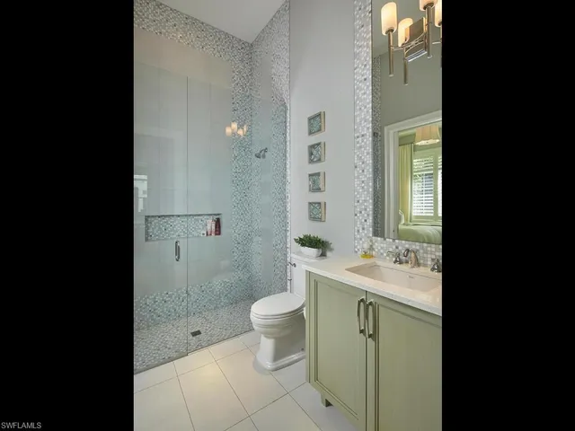 a bathroom with a granite countertop toilet a sink and a mirror