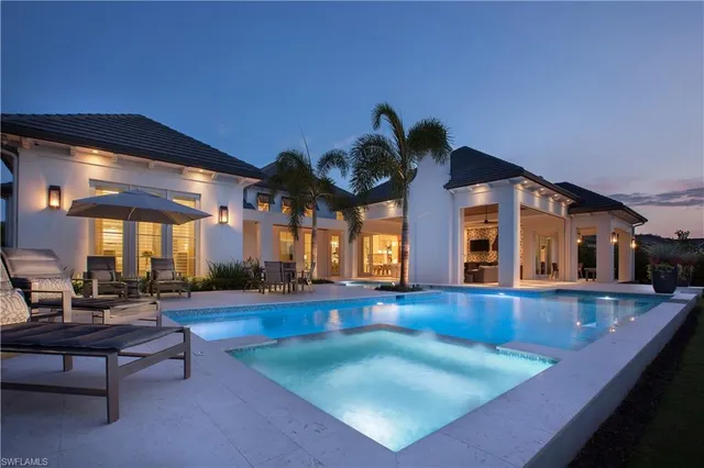 a view of a house with swimming pool and sitting area