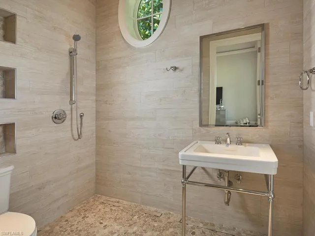 a bathroom with a sink a toilet and a mirror