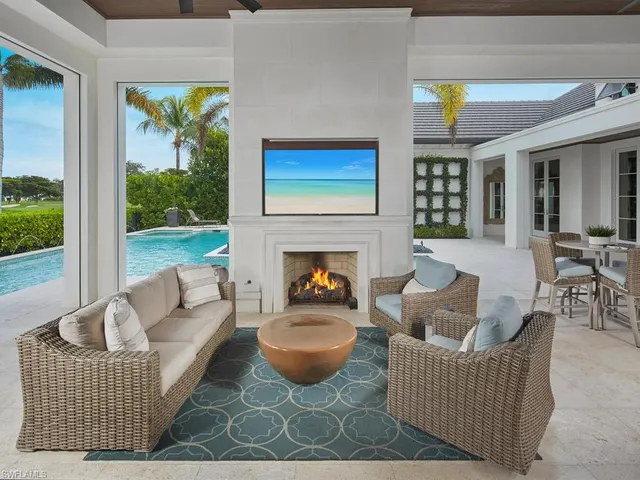 a living room with furniture a fireplace and a floor to ceiling window
