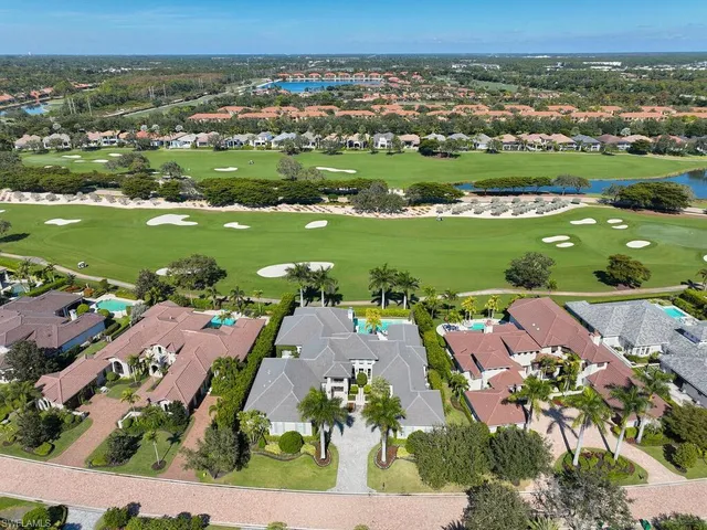 an aerial view of residential houses with outdoor space and lake view