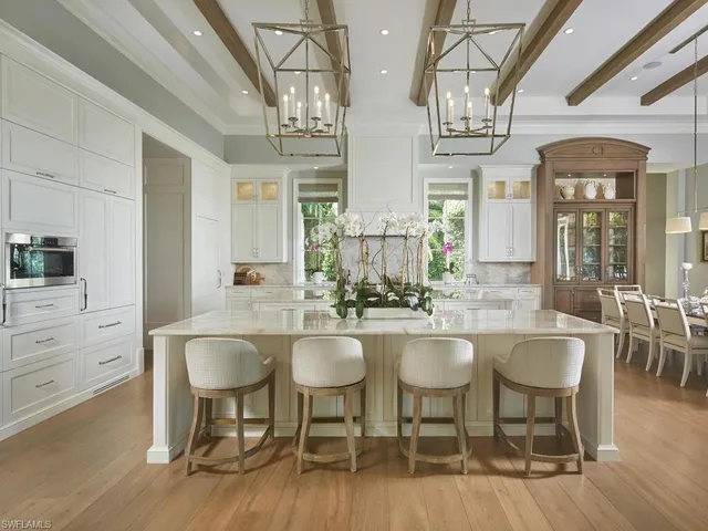 a kitchen with a dining table chairs and chandelier