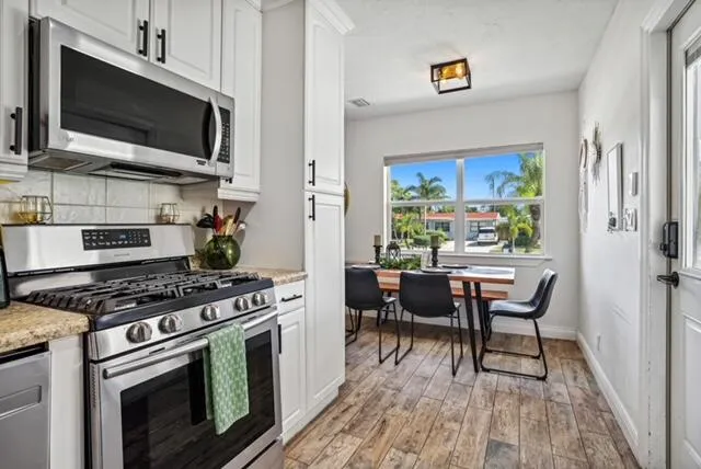 a kitchen with stainless steel appliances a stove a sink and a microwave