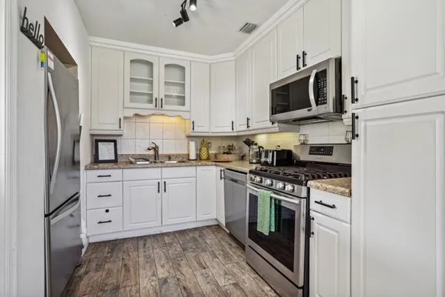 a kitchen with stainless steel appliances granite countertop a stove a refrigerator and a microwave