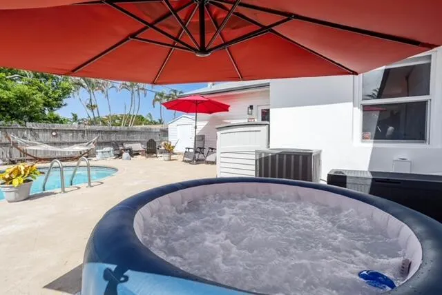 a view of a backyard with a table and chairs under an umbrella