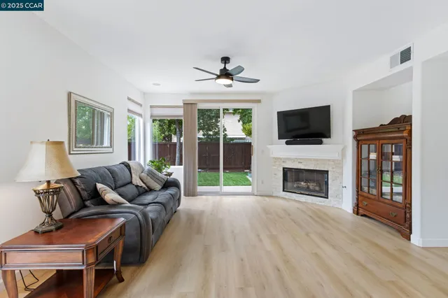 a living room with furniture a fireplace and a flat screen tv