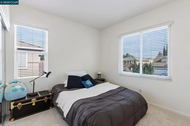 a bedroom with a bed and windows