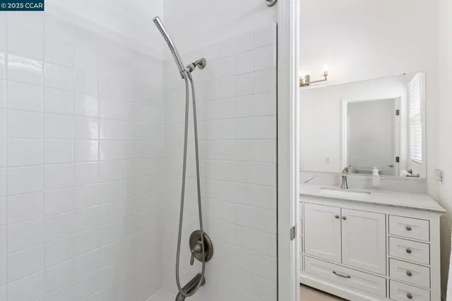 a bathroom with a granite countertop sink a mirror a vanity and a shower
