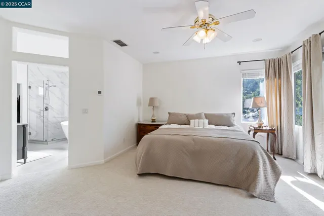 a spacious bedroom with a bed and a chandelier