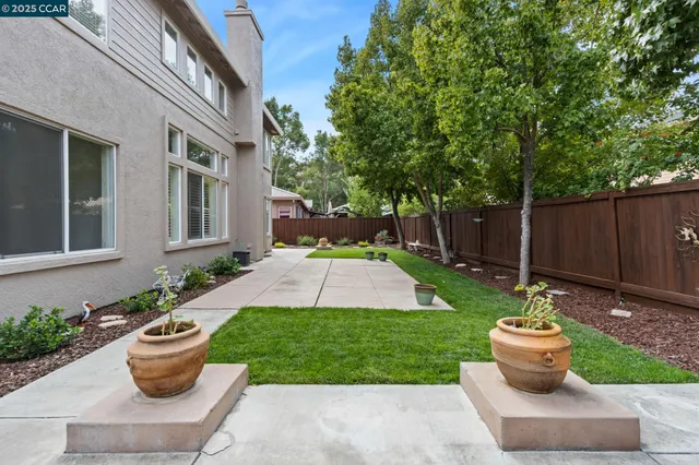 a view of a backyard with table and chairs plants