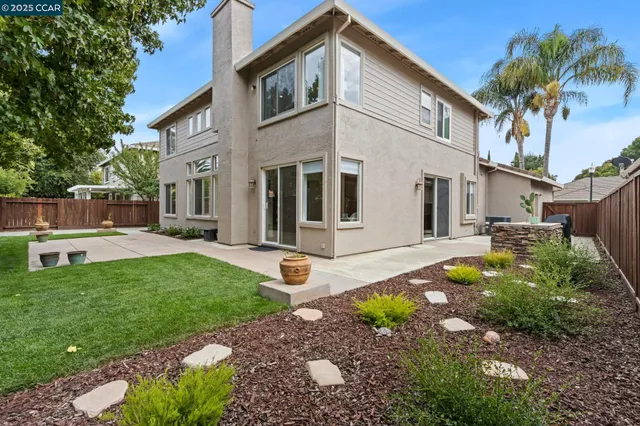 a view of a house with backyard and sitting area