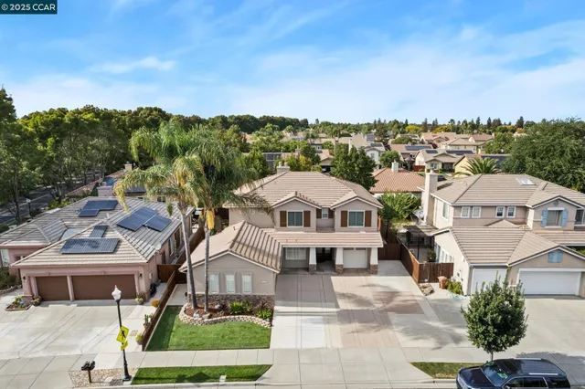 a view of a big house with a big yard plants and large trees