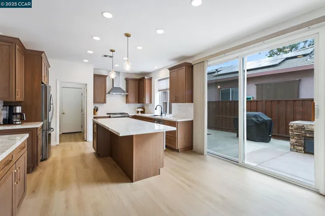 a large kitchen with stainless steel appliances kitchen island granite countertop a large counter top and a stove