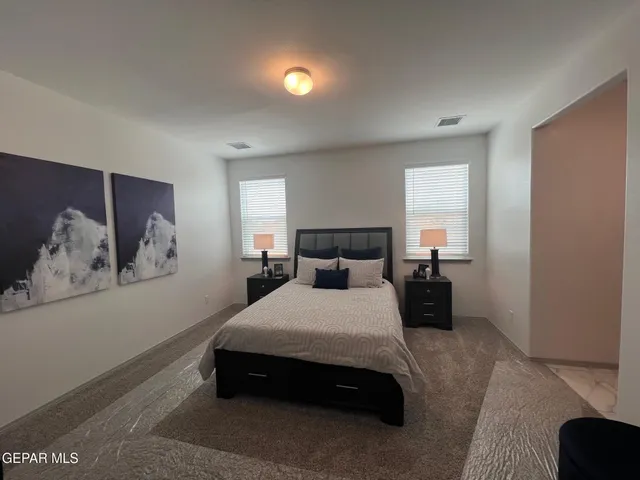 a bedroom with a bed and a painting on the wall