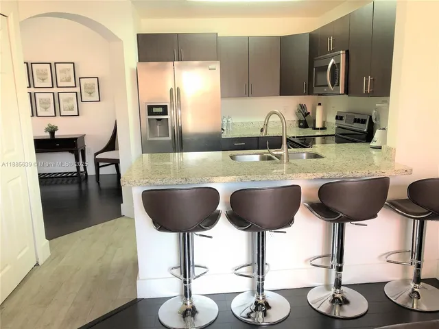 a kitchen with stainless steel appliances granite countertop a sink and cabinets